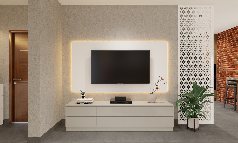An entertainment unit with an LED-backlit wall panel and a low lying cabinet for 1bhk flat interior design