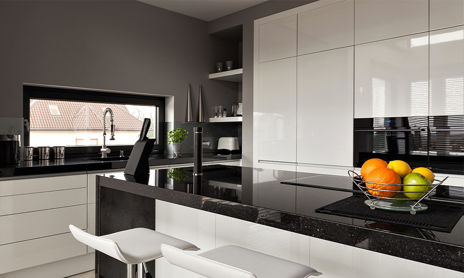 Kitchen with a black granite slab, offering durability, resistance to scratches, heat, and stains for high-traffic areas.