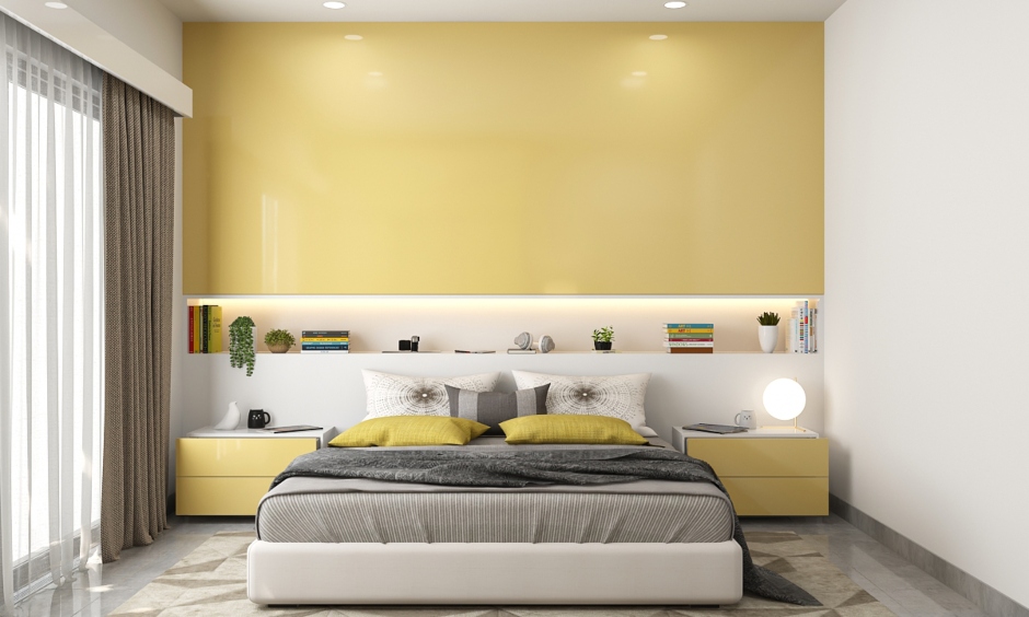 The guest room is designed with a sliding door wardrobe finished in white and yellow high gloss laminate in a 2bhk house interior design