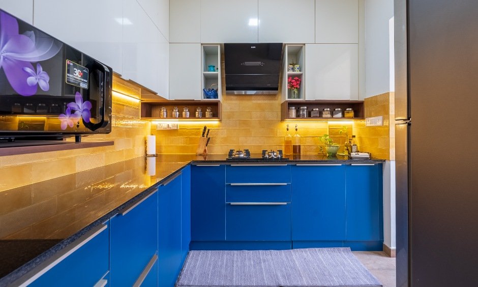An L-shaped modular kitchen in Tejaswini Nagar, Bengaluru with blue and white design