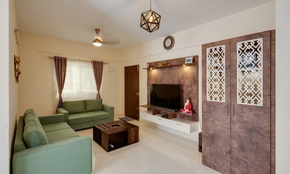 Modern living room with wall-paneled TV unit and a pooja room designed in Whitefield