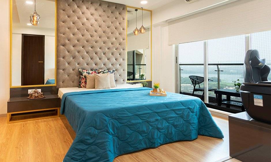 Master bedroom with an attractive tufted headboard with a mirror on either side of the bed designed by good interior company in mumbai