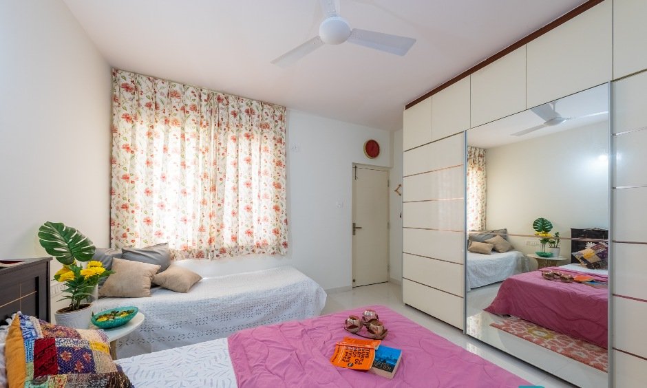 A minimalist bedroom with a sliding wardrobe in Bengaluru features a built-in mirror