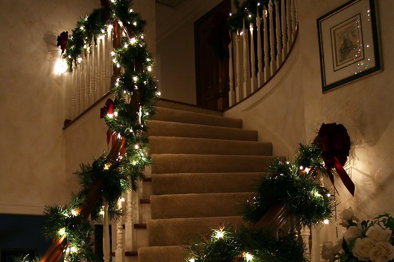 Staircase christmas decoration with eclectic Christmas garland and fairy lights to infuse christmas spirit