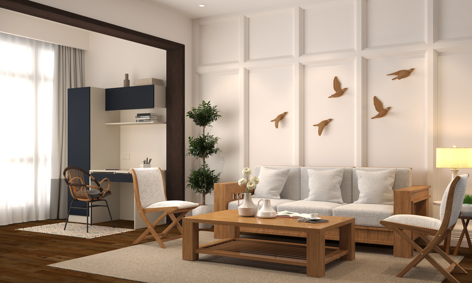 Two wooden folding chairs are positioned across a wooden diwan, with a coffee table set against off-white walls.