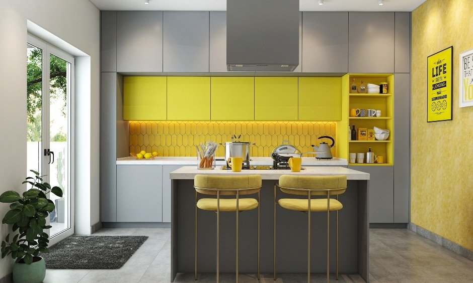 Grey furniture kitchen with yellow accents, island with hob, mix of grey and yellow cabinets, tiled backsplash.